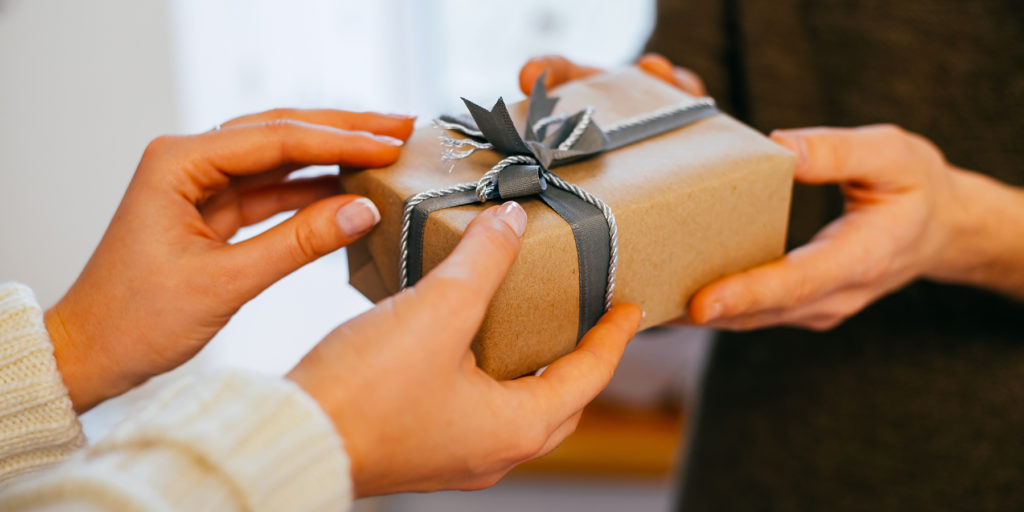 Close up of a young couple's hands as they exchange a gift