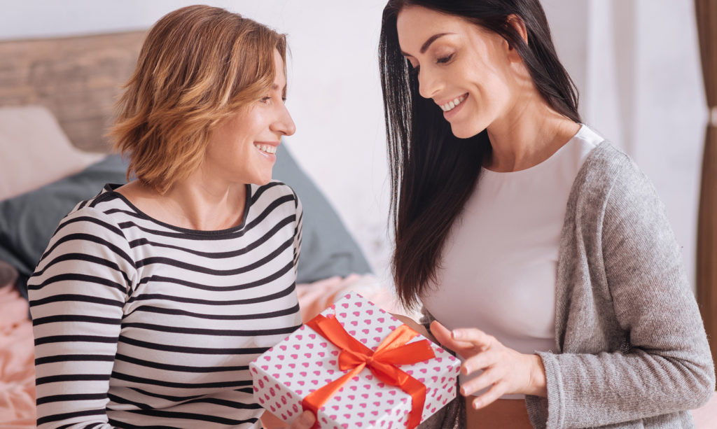 Woman surprising her wife with an anniversary gift