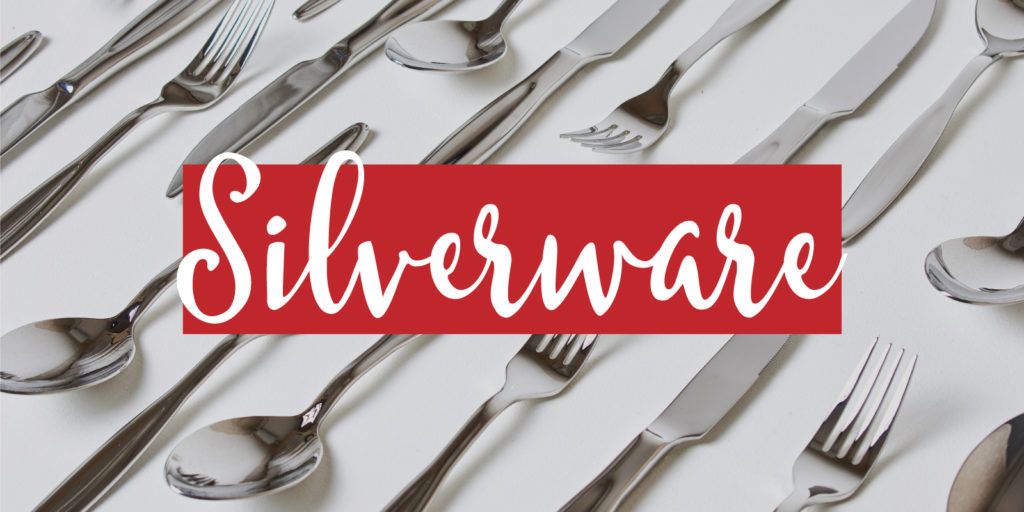 Multiple pieces of silverware layed out in rows with a text overlay that reads "silverware"