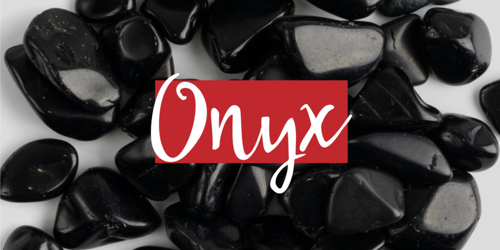 Closeup of a pile of black stones with a text overlay that reads 'Onyx'