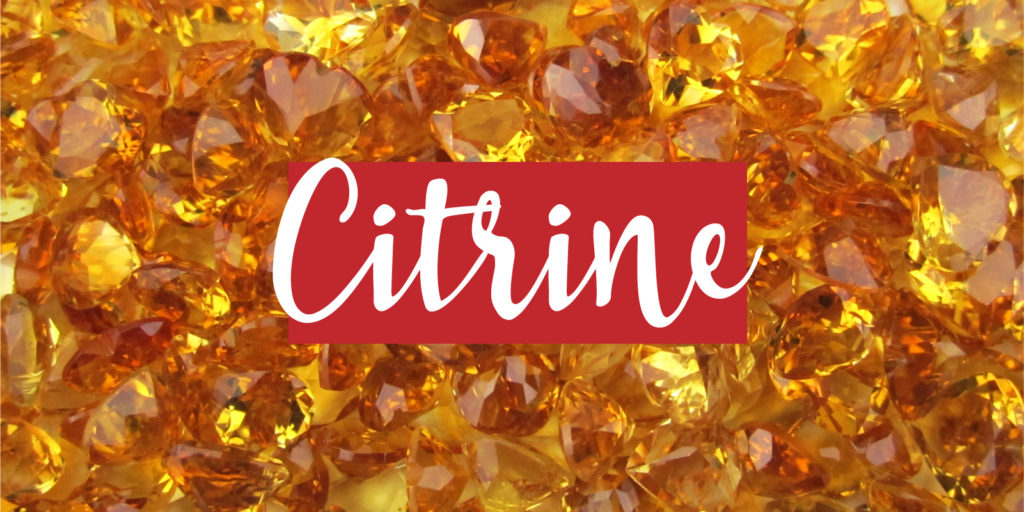 Overhead image of a pile of yellow gemstones with a text overlay that reads 'citrine'