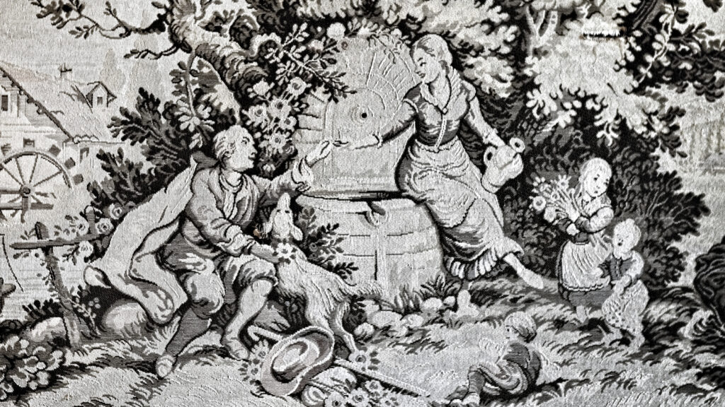 Detail of a tapestry circa 18th century featuring a man and woman exchanging a gift at at a water fountain with their children nearby