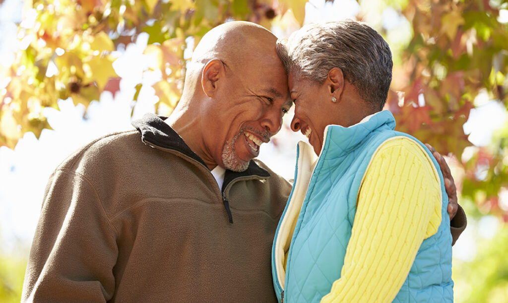 Candid portrait of a loving african american couple smiling and embracing outdoors.